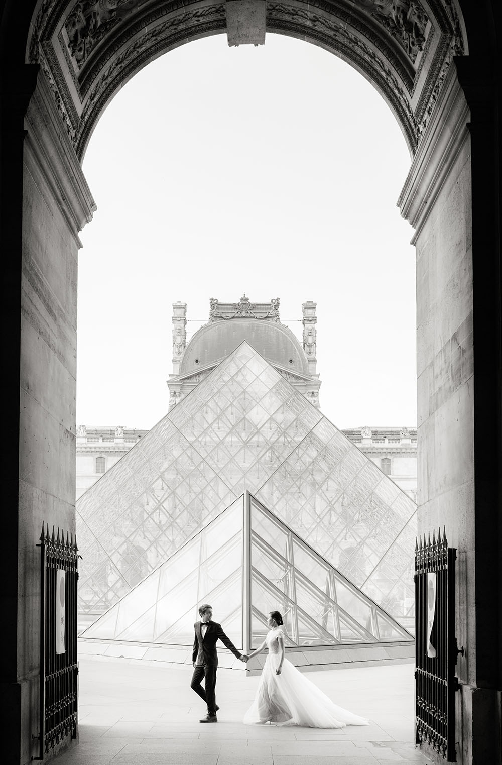 un couple s embrasse a coté des pyramide du louvre il fait nuit